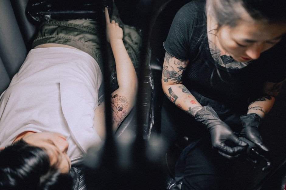 Client discussing custom tattoo design with artist