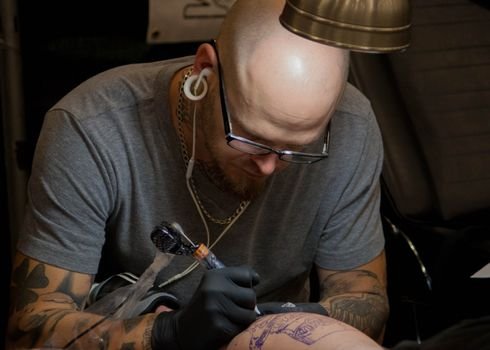 Experienced tattoo artist at work